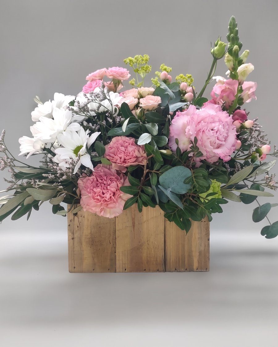 Flores en caja de madera en rosa